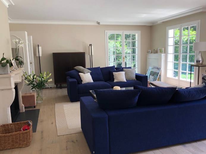 Salon aux canapés bleus d'une maison de 350m2 rénové par l'architecte d'intérieur Sophie Jacquemin Interior Design basée à Genève